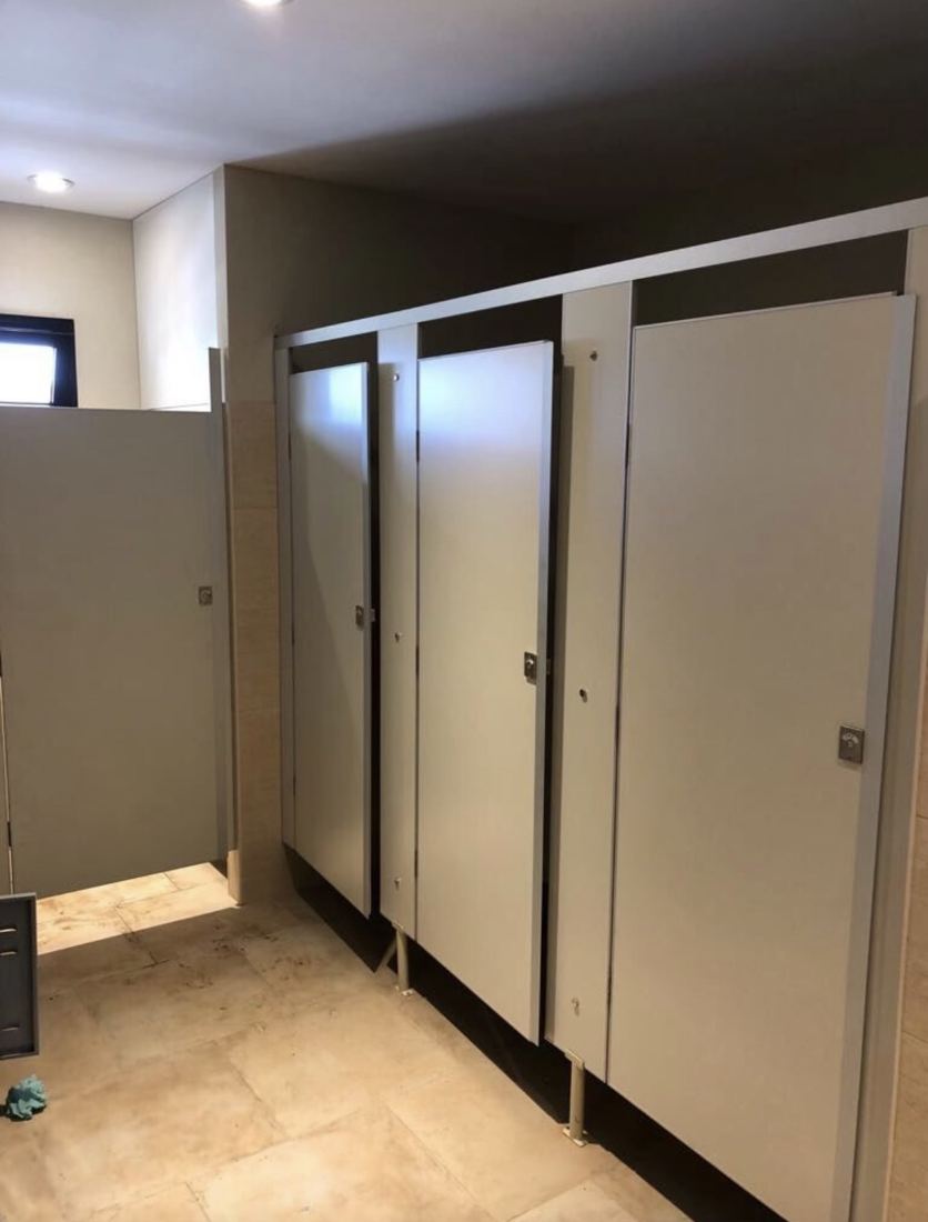 Batería de box sanitarios de melamina gris con puertas y cerrojos